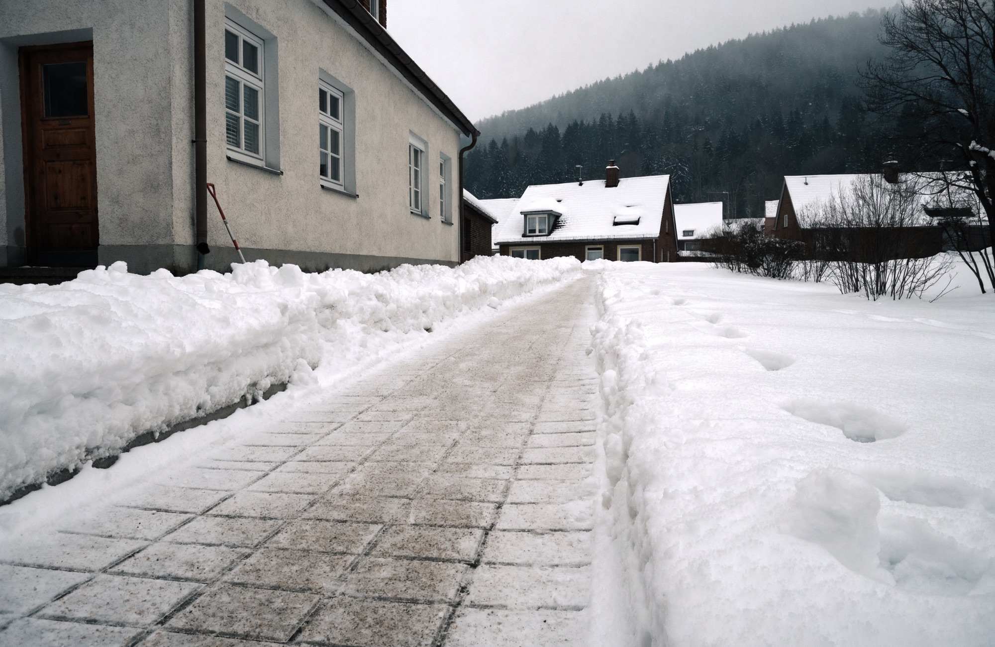 Geräumter Gehweg vor einem Haus im Winter